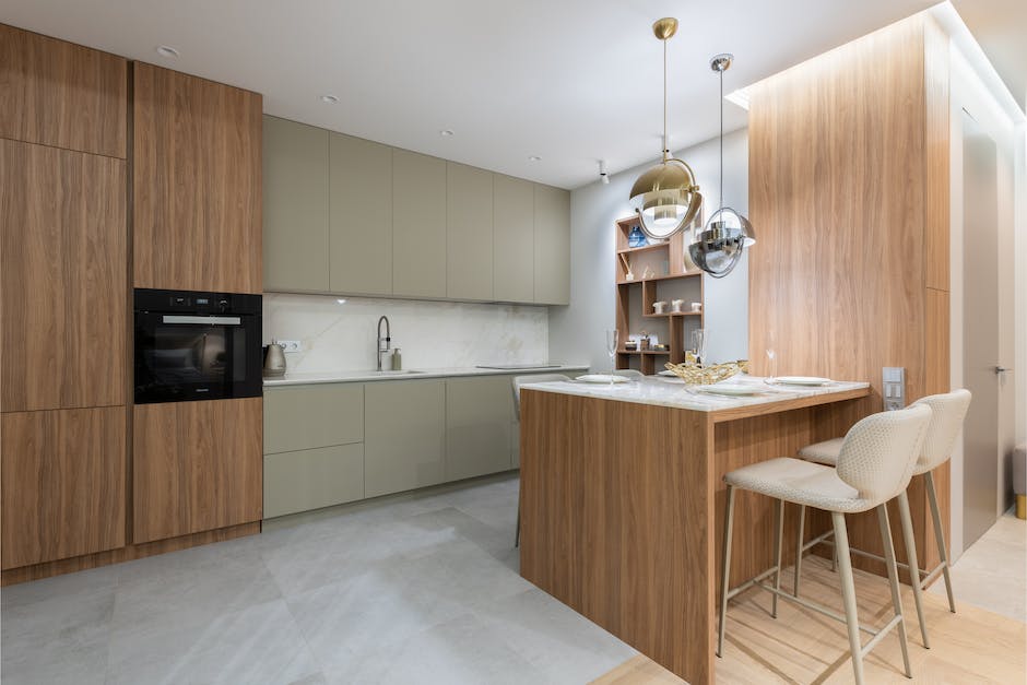 Interior of bright modern kitchen with cupboards near chairs with counter decorated with glasses and plates under lamps next to shelves on wall